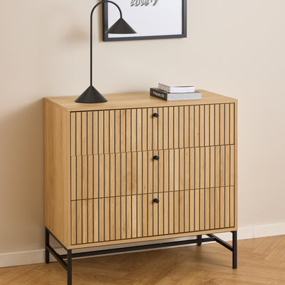 Bambouz chest of drawers (81x81) beneath a wall hanging, with a black lamp and books – a slatted chest of drawers for the living room