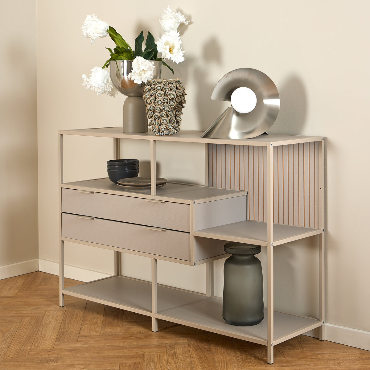 Skeleto low bookcase, 114x78, grey melamine, with white flowers in a vase and a silver lamp on the top