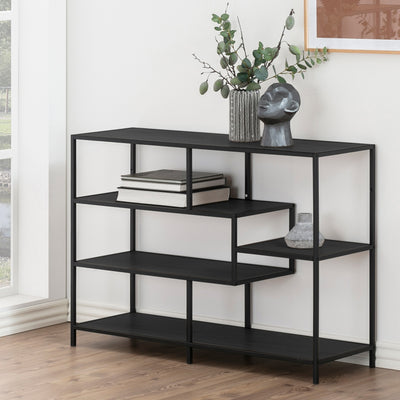 Skeleto bookcase, 114x78, black melamine, by the window with twigs in a vase, a sculpture and books – a black bookcase for the living room