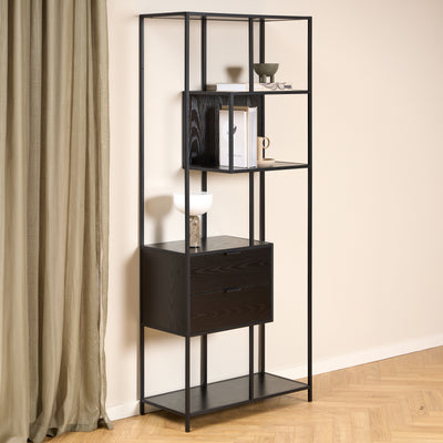 Skeleto bookcase, 77x185, black melamine, against a light-coloured wall and a linen curtain, with a lamp and books