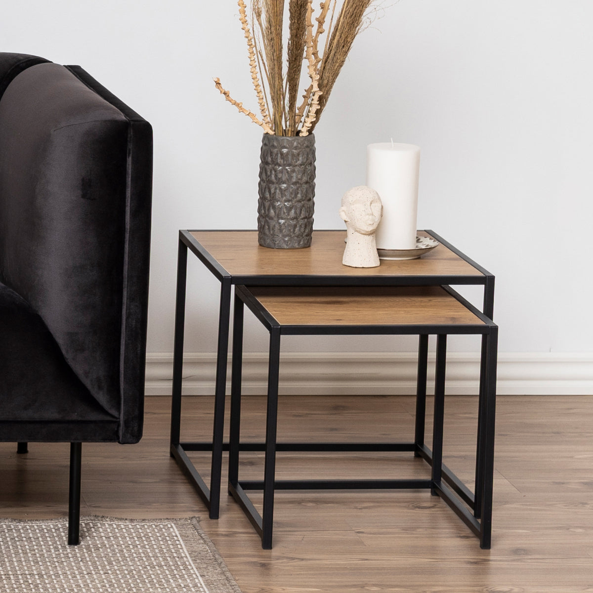 Skeleto 50x45 Wild Oak coffee tables next to a dark velour sofa, with a vase and a candle – coffee tables for the living room