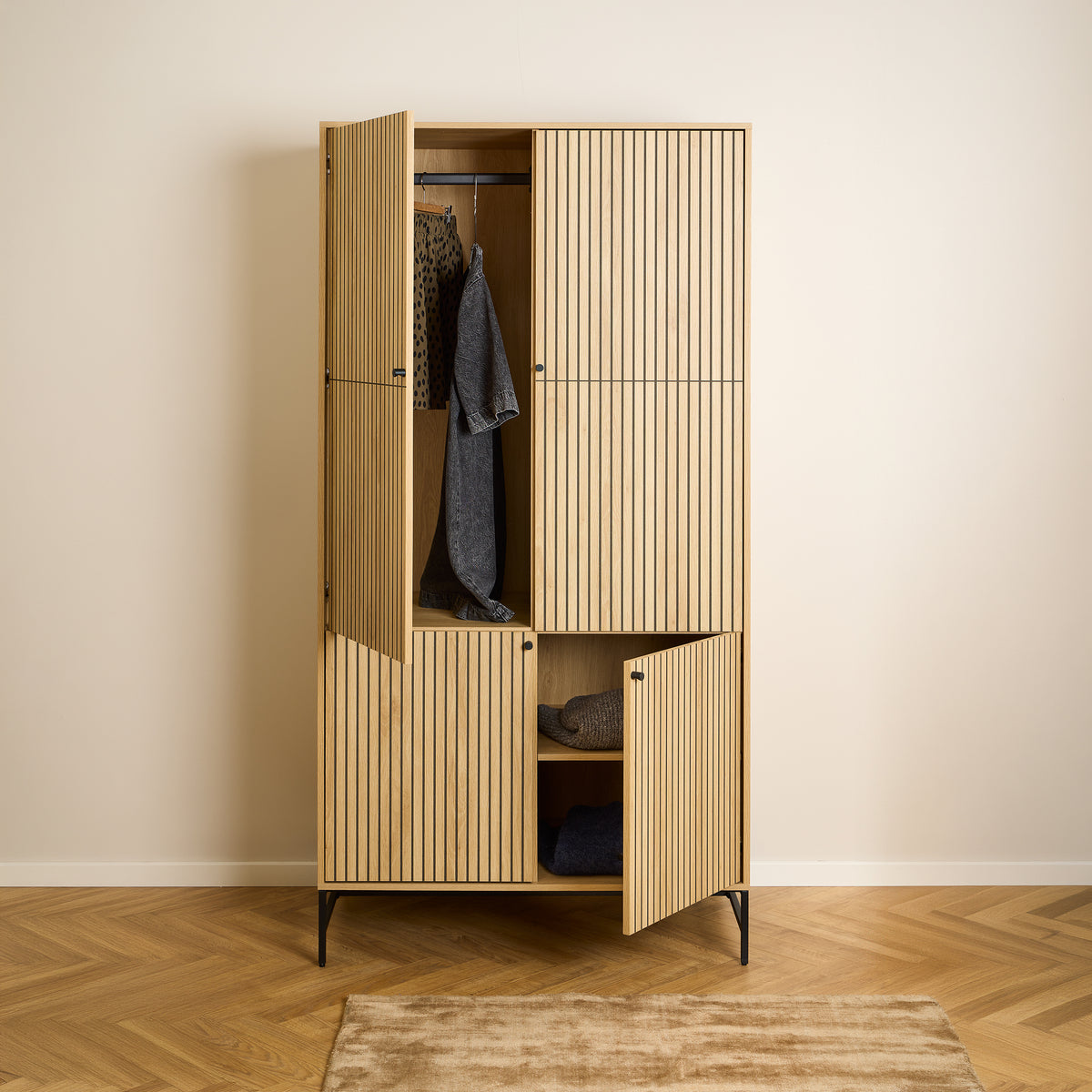 Bambouz wardrobe, 99x200, on a herringbone-patterned floor – open doors, clothes on a rail and jumpers on a shelf, bedroom wardrobe