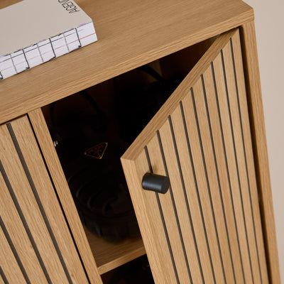 Bambouz 99x141 shoe cupboard – detail of the half-open door with a black handle and shoes on the shelf