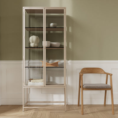 Skeleto 77x186 Grey Melamine display cabinet against an olive-coloured wall next to a wooden chair – a display cabinet for ceramics and books
